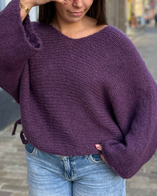 Pull violet à col V et manches chauve-souris porté avec un jean