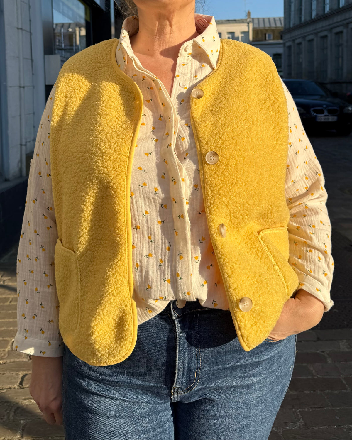 Chemisier écru à motifs jaunes femme porté avec gilet sans manches jaune