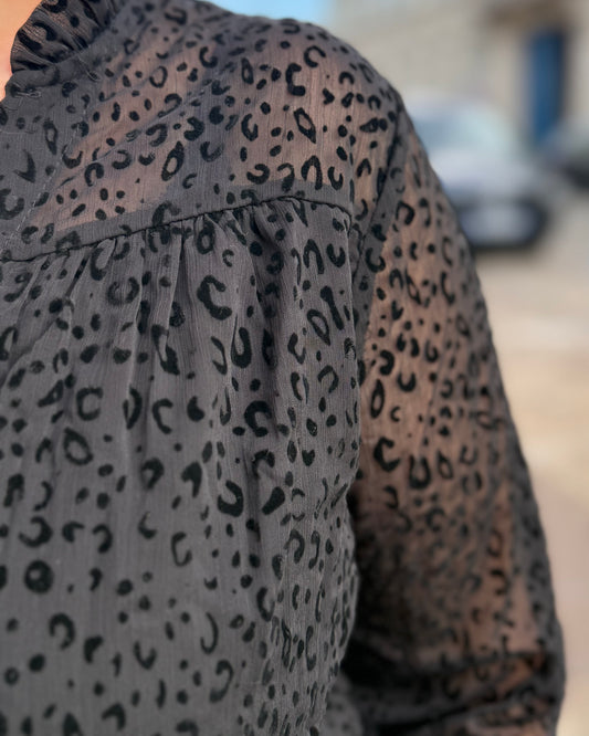 Gros plan sur le tissu noir à motifs texturés de la chemise