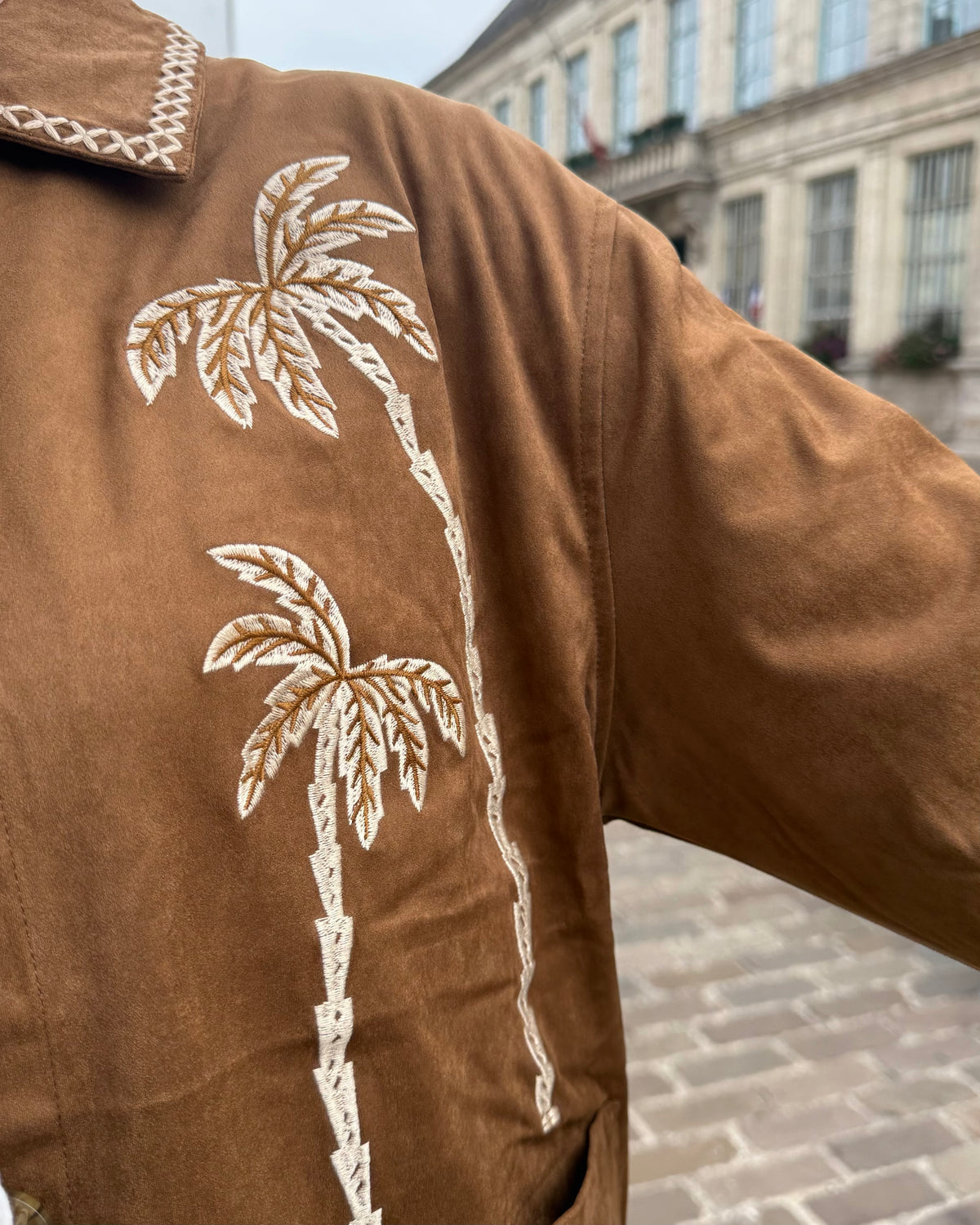 Détail des broderies palmiers sur la veste marron femme