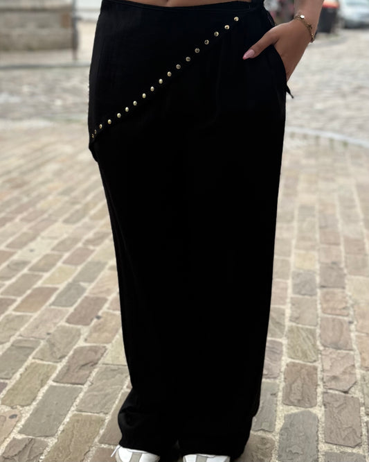 Pantalon noir femme coupe large avec pan asymétrique et détails cloutés